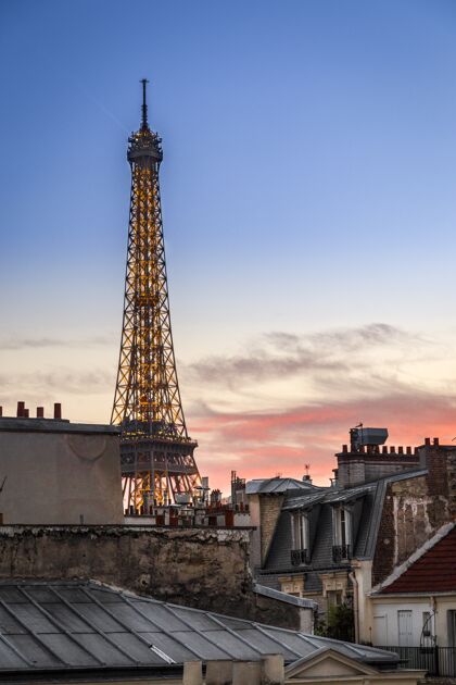 天际线法国巴黎粉红色日落时埃菲尔铁塔的垂直拍摄天空塔公园