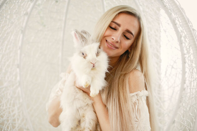 兔子一个金发碧眼的女孩 怀里抱着一只白兔休闲女孩放松