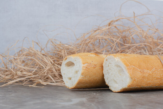 健康在大理石表面切半块法式面包膳食小面包硬皮