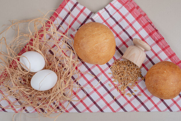 新鲜的桌布上有燕麦粒的圆面包燕麦食品鸡蛋