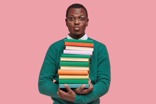 男人年轻的非洲裔美国学生拿着一堆书人学生成年人