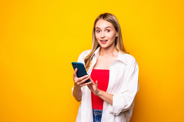 女士年轻女子用手机聊天的画像 隔着黄色的墙壁魅力人自信