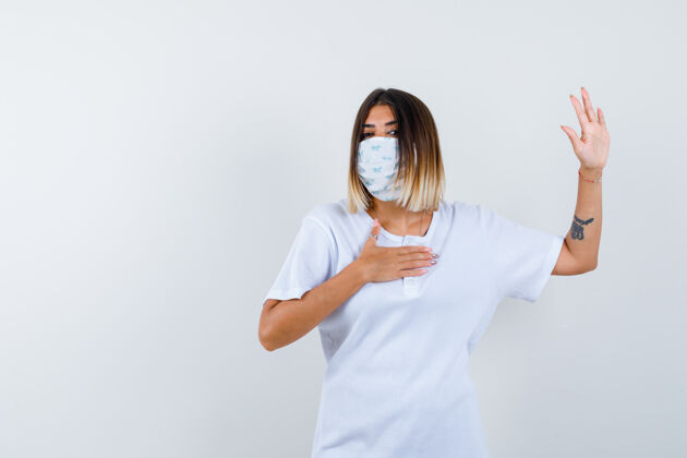健康一位年轻女性穿着t恤 戴着口罩 摆出一副严肃的前景色Ortrait显示护理