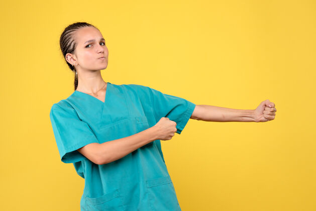 黄色正面图身穿医用衬衫的女医生 彩色医院护士柯维德-19病毒肖像医学医院