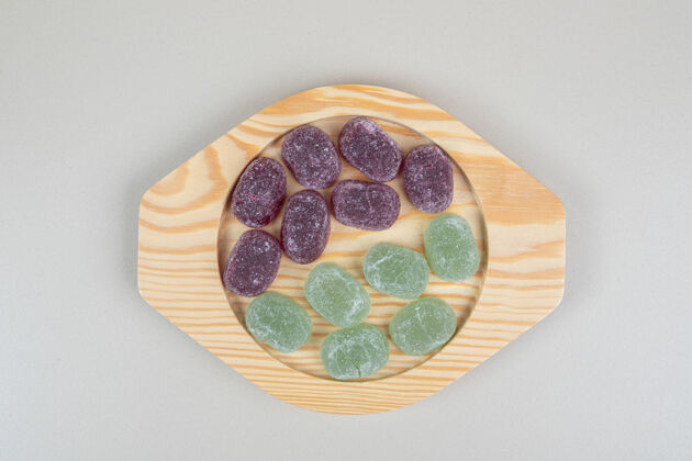甜点绿色和紫色的果冻糖果放在木盘上糖果果酱明胶