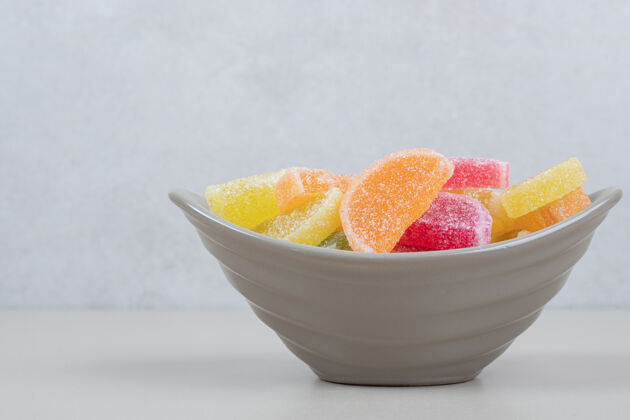 甜点甜甜的彩色果冻糖果在米色的碗表面什锦糖果明胶