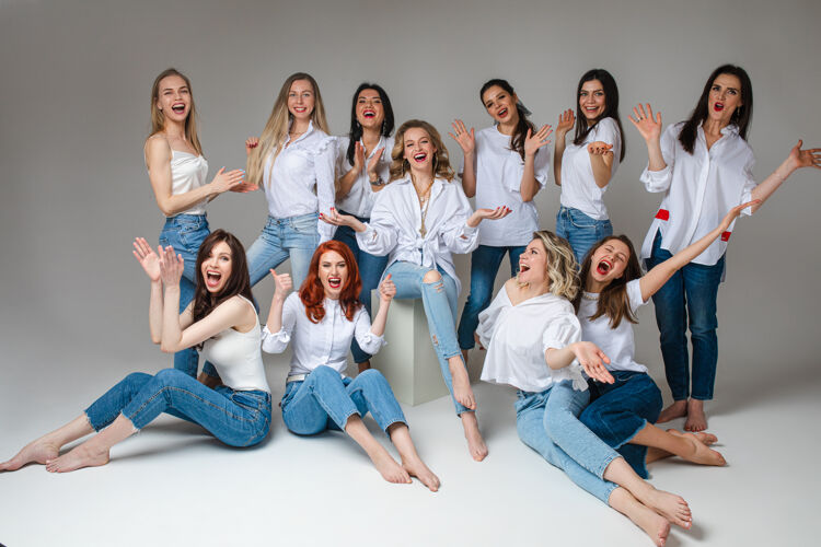 大笑女人团结的概念快乐年轻的女队时尚的工作人员穿着牛仔裤摆姿势休闲同事单身