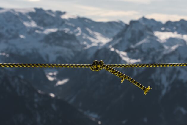 风景特写镜头中的一条扭曲的绳子在雪山前阿尔卑斯山运动雪
