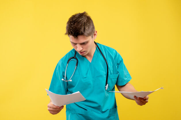 病毒黄色墙壁上的男医生穿着医疗服的前视图和分析情绪健康分析