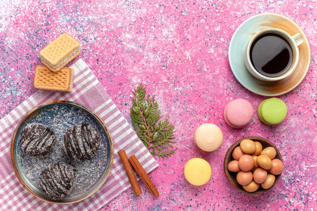 派俯瞰美味的巧克力蛋糕 配上一杯茶和粉红色的麦卡龙桌子水果食物