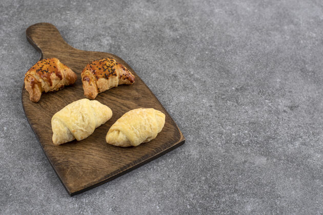 面包屑石头桌上放着新鲜饼干的木板松脆短面包小吃