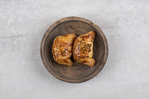 餐盘自制的羊角面包放在木板上 放在大理石桌上饼干甜点烘焙
