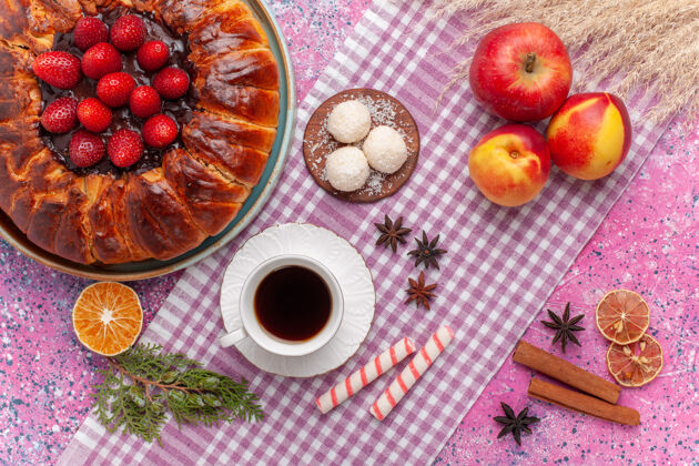 圆顶视图美味的草莓派和一杯茶在粉红色的地板上美味椰子咖啡