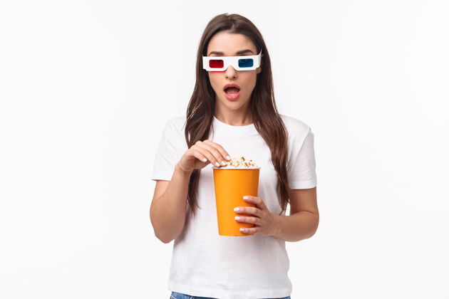 庆典一个吃着爆米花 戴着3d眼镜的年轻女人表达女孩复活节