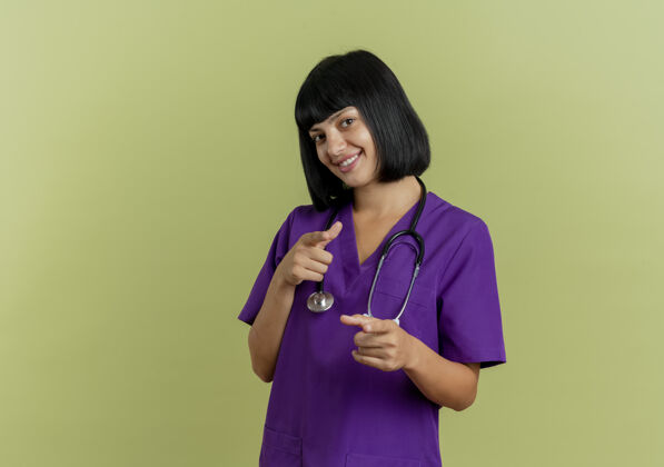 手笑容可掬的年轻黑发女医生穿着制服用听诊器点着双手年轻微笑空间