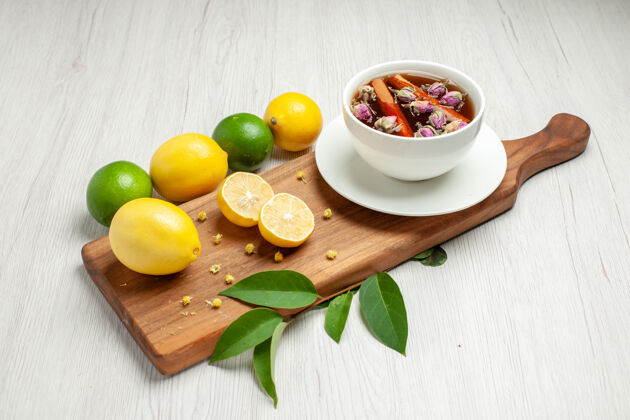 苹果前视图新鲜柠檬与一杯茶放在白色的桌子上柑橘柠檬新鲜果汁酸可食用水果水果茶