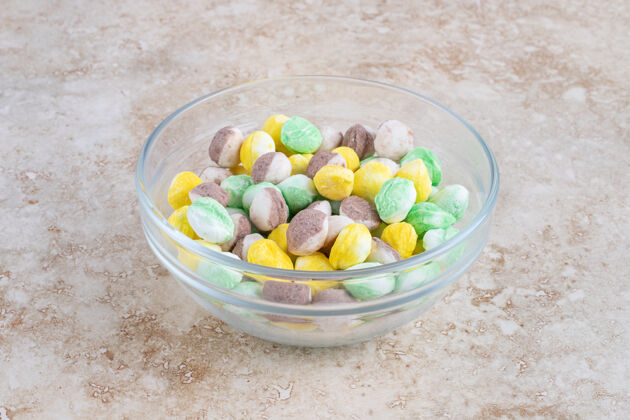 碗五颜六色的糖果放在碗里 放在大理石桌上甜点卡路里零食