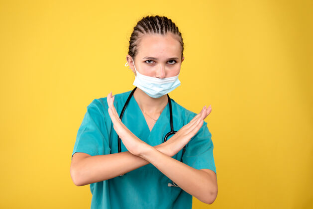 面具黄色墙壁上戴着无菌防护面具的女医生的正视图肖像医院正面