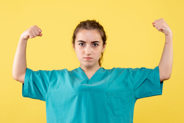 衬衫身穿医用衬衫的年轻女医生在黄色墙壁上弯曲的正视图健康成人肖像