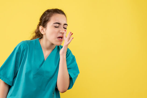 鼻子身着医疗服的年轻女医生在黄色墙壁上清洗鼻子的正视图西装人清洁