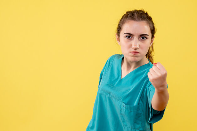正面黄墙上年轻女医生穿着医用衬衫怒气冲冲的正面图衬衫成人病毒