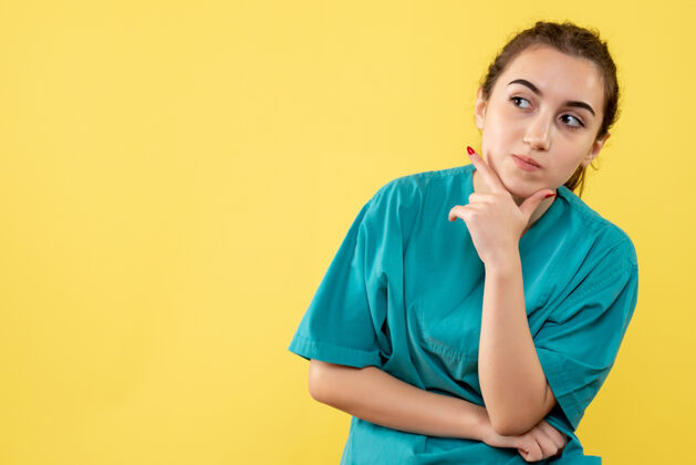 医疗黄色墙壁上穿着医疗服的女医生的正视图自信漂亮情绪
