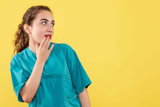 医院黄墙上年轻女医生穿着医用衬衫的正面图健康耳机病毒
