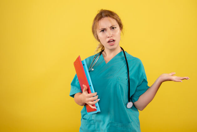 病毒黄墙上穿着医疗服拿着不同分析的女医生正面图前面不同女医生