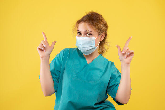 健康黄墙上年轻女医生穿着医疗服 戴着口罩的正面图脸面具医院