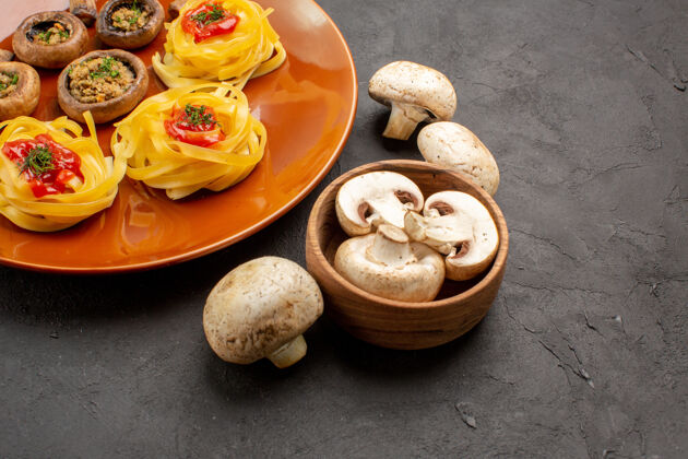 食物前视图油炸蘑菇和面团在黑暗的餐桌上的食物晚餐面食刷新坚果贝壳