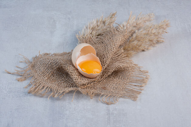 蛋黄蛋黄在一块破壳上放在一块布上放在大理石桌上配料营养有机
