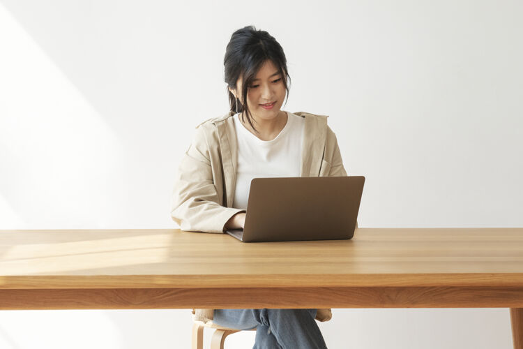 室内快乐的亚洲女人在家工作木桌数字设备女性
