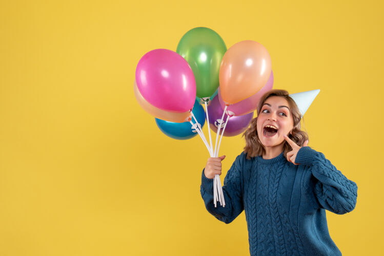 情感正面图：带着彩色气球的年轻女性气球年年轻女性