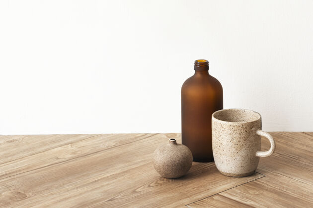 陶瓷杯木质地板上的棕色花瓶旁边有一个极小的咖啡杯复制空间室内陶瓷