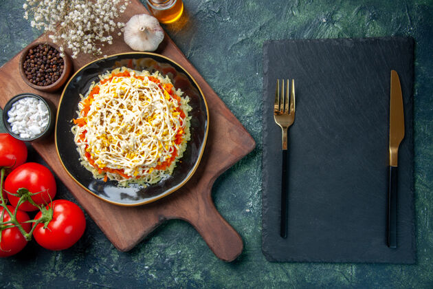 食物顶视图美味含羞草沙拉在盘子里与深蓝色背景上的红色西红柿晚餐深蓝色红色