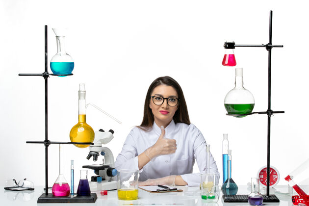 微笑前视图穿着白色医疗服的女化学家坐在白色背景上微笑着实验室病毒冠状病毒大流行科学坐着实验室科学