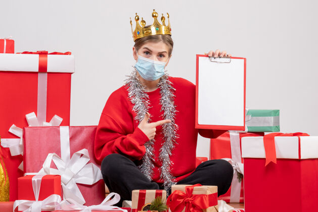 便条前视图年轻女性坐在圣诞礼物与注意颜色礼物病毒