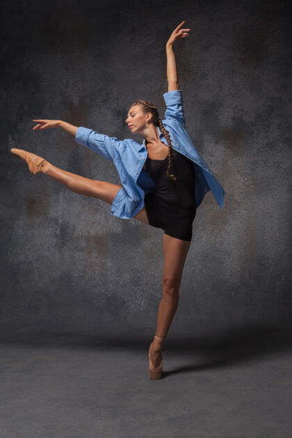 芭蕾舞演员年轻漂亮的现代风格的舞者在一个工作室灰色的背景上摆姿势蓝色衬衫感性人体运动