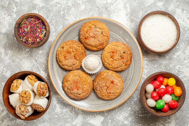 盘子顶视美味的沙饼干与糖果浅白色背景烘焙食品背景烹饪