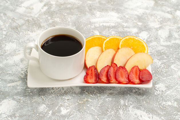 马克杯前视图一杯咖啡 苹果片 橙子和草莓 浅白色背景 水果成熟 新鲜 醇厚草莓茶早餐