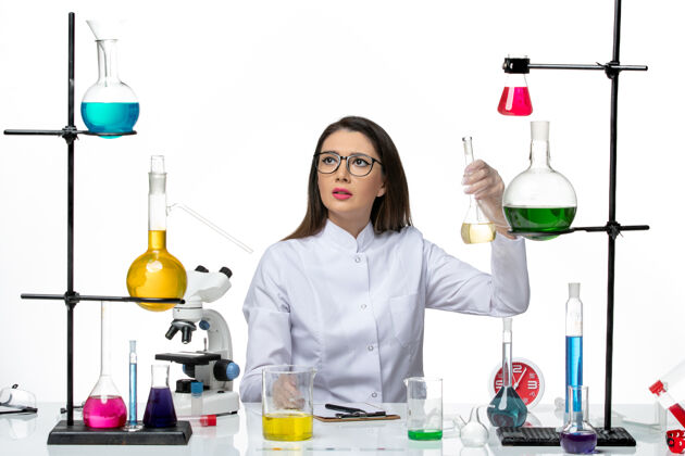 大流行前视图穿着白色医疗服的女化学家拿着白色背景上的溶液-科学大流行实验室病毒观点科学病毒