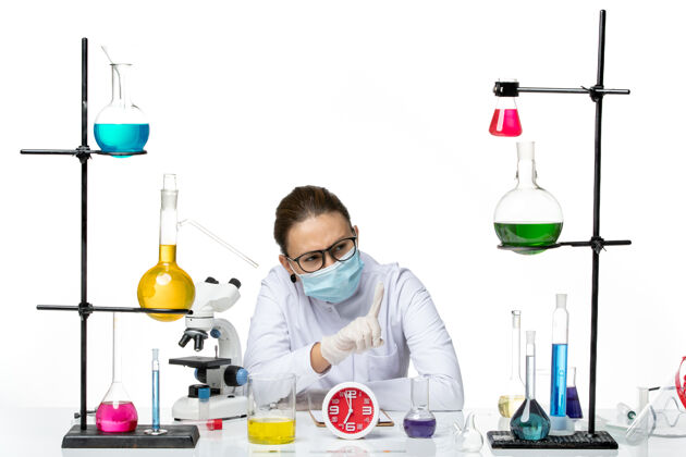 病毒前视图穿着医疗服的女化学家带着面罩坐在白色背景上 溅起实验室病毒化学冠状病毒医生医学医学
