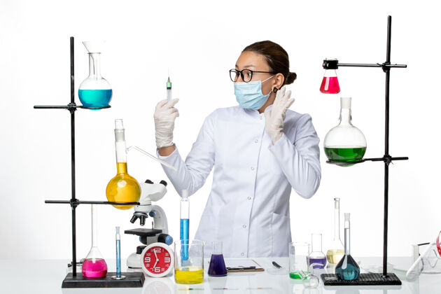 药物前视图：身穿医疗服的女化学家 戴着面罩 在白色背景上注射病毒化学实验室的covid-splash实验室实验室外套