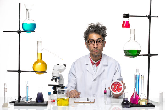 实验室正面图身穿医疗服的男科学家在白色办公桌上拿着时钟化学健康冠状病毒-实验室病毒前面外套诊所