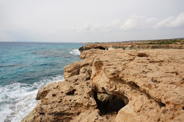 全景塞浦路斯白天岸边的大石头希腊棕榈树海洋
