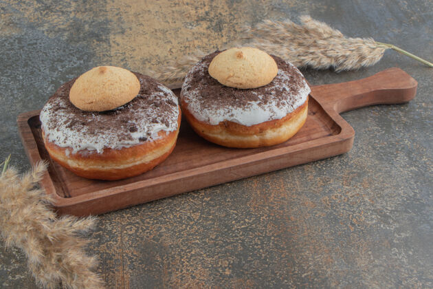 风味甜甜圈上的饼干放在木桌上的木板上美味甜点美味