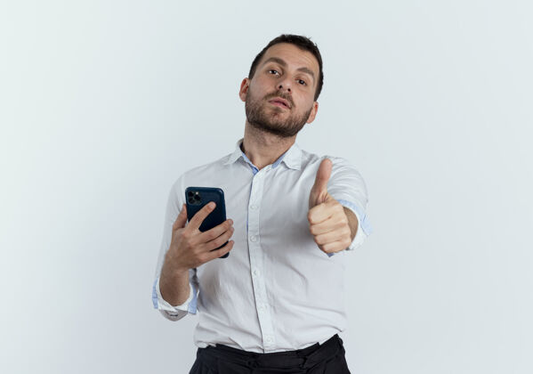 优雅自信的帅哥拿着手机 竖起大拇指孤零零地站在白墙上电话自信年轻