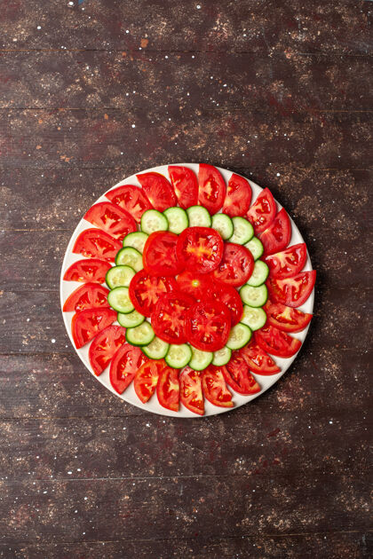 晚餐顶视图新鲜的红色西红柿切片黄瓜新鲜沙拉上的棕色空间切片生的盘子