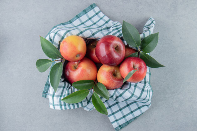 水果苹果堆在一个篮子里 上面盖着毛巾 放在大理石上美味多汁新鲜