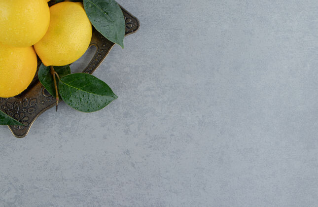 美味一捆柠檬和叶子放在大理石上华丽的托盘上柑橘饮食柠檬